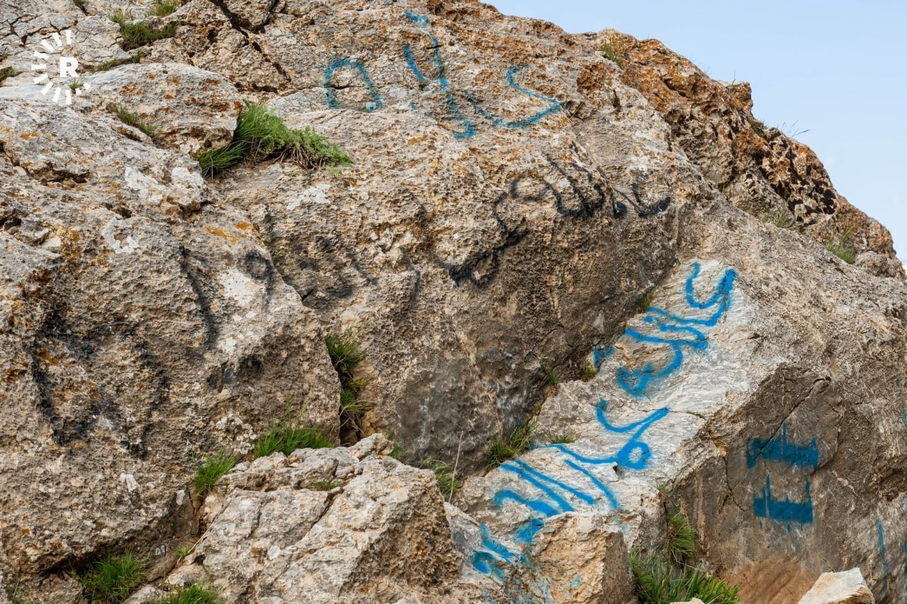 تشويه صخرة أثرية في أربيل بكتابات عربية وأجنبية (صور)